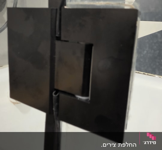 ציר זכוכית שחור במקלחת עם רקע אריחים
